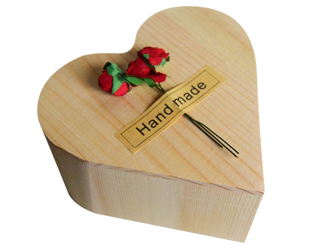 rosa in una scatola di legno a forma di cuore