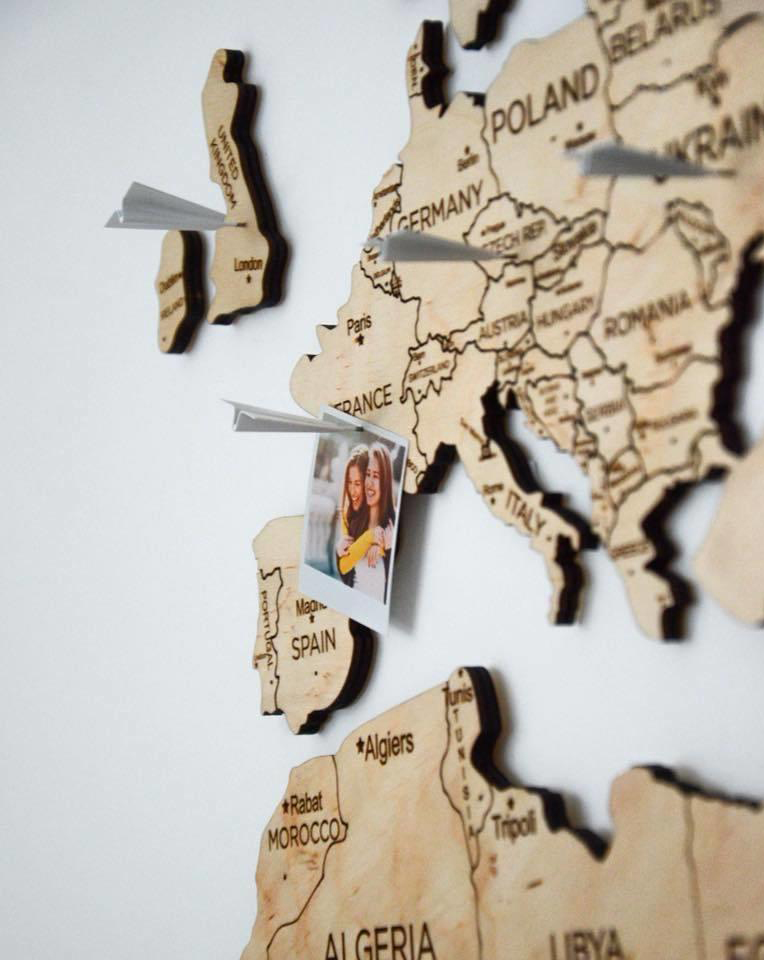 I continenti della mappa del mondo di viaggio colorano il legno chiaro